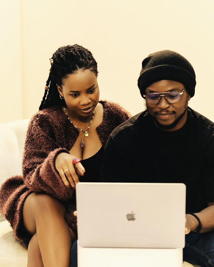 Two people on a couch looking at a laptop together